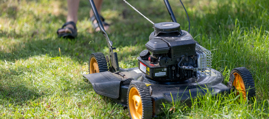 person mowing the lawn at the end of summer